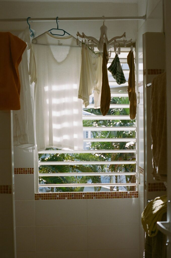 Badezimmer mit Fenster und Wäsche auf einem Wäscheständer